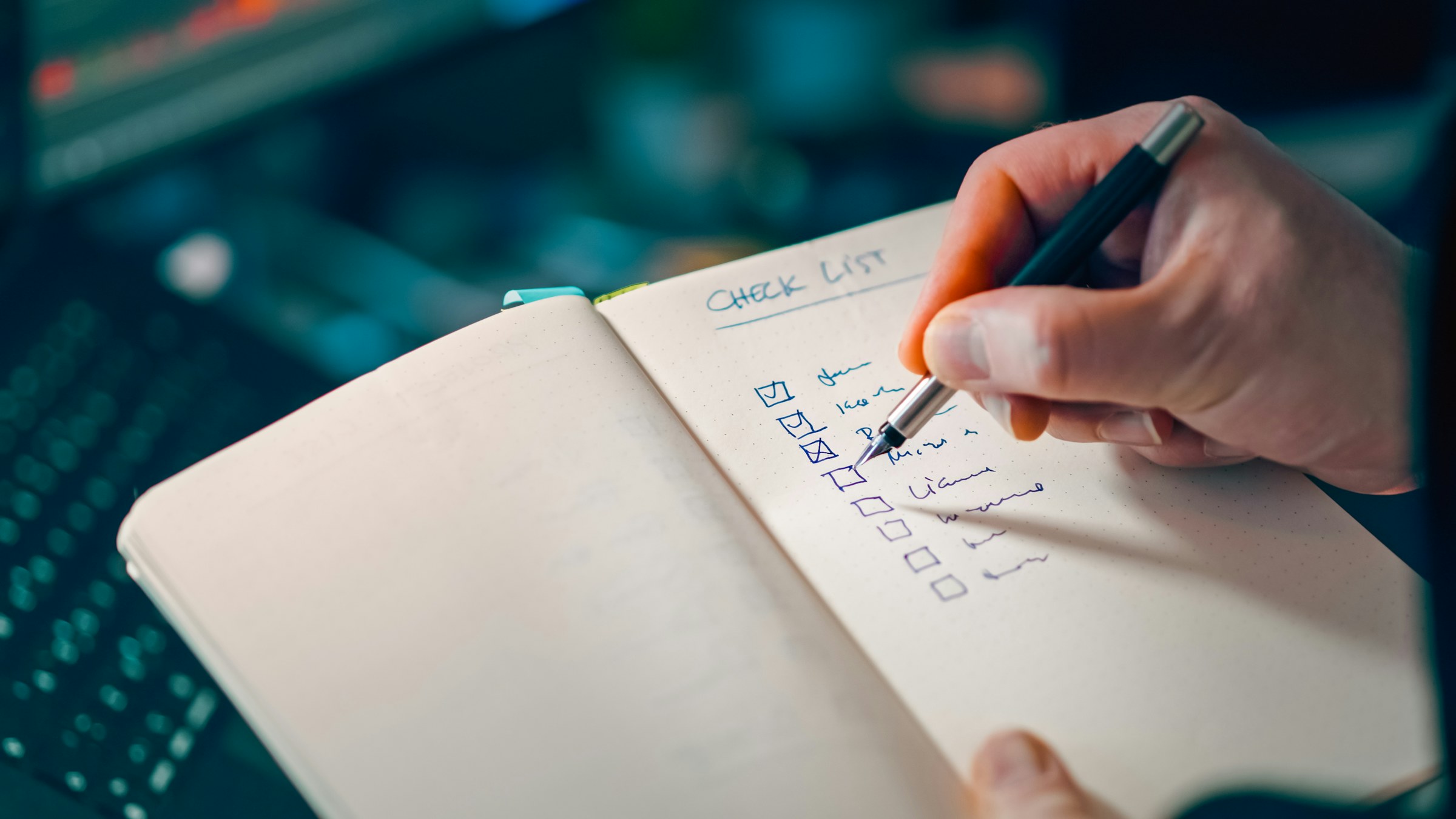 A hand reviewing a written action checklist